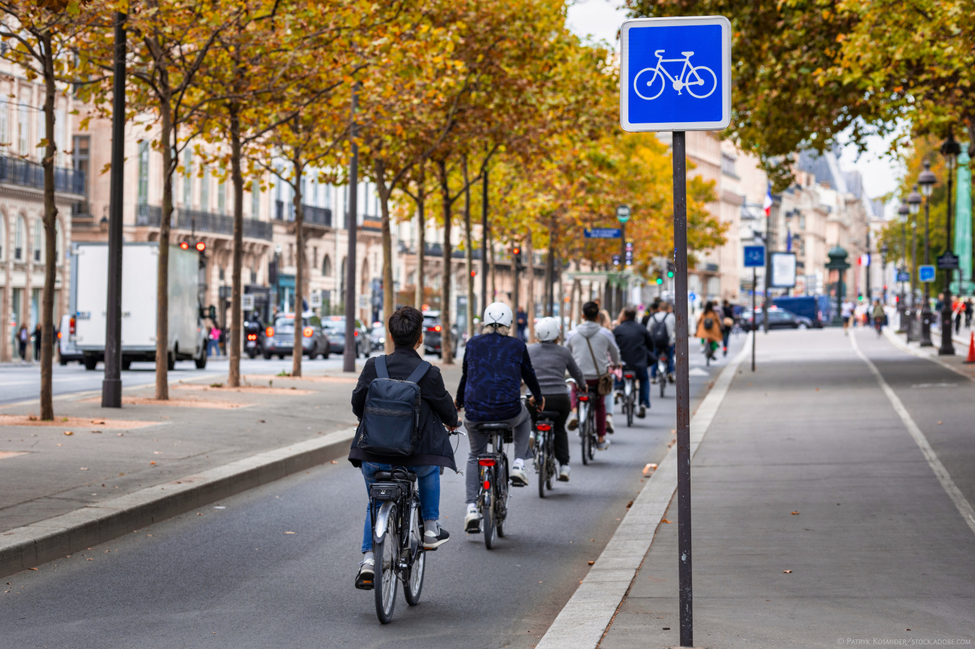 Ein Radweg in Paris, auf dem mehrere Radfahrer*innen hintereinander durch die Stadt fahren